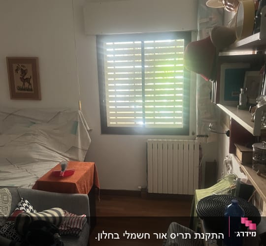 חלון עם תריסי אלומיניום בחדר מואר